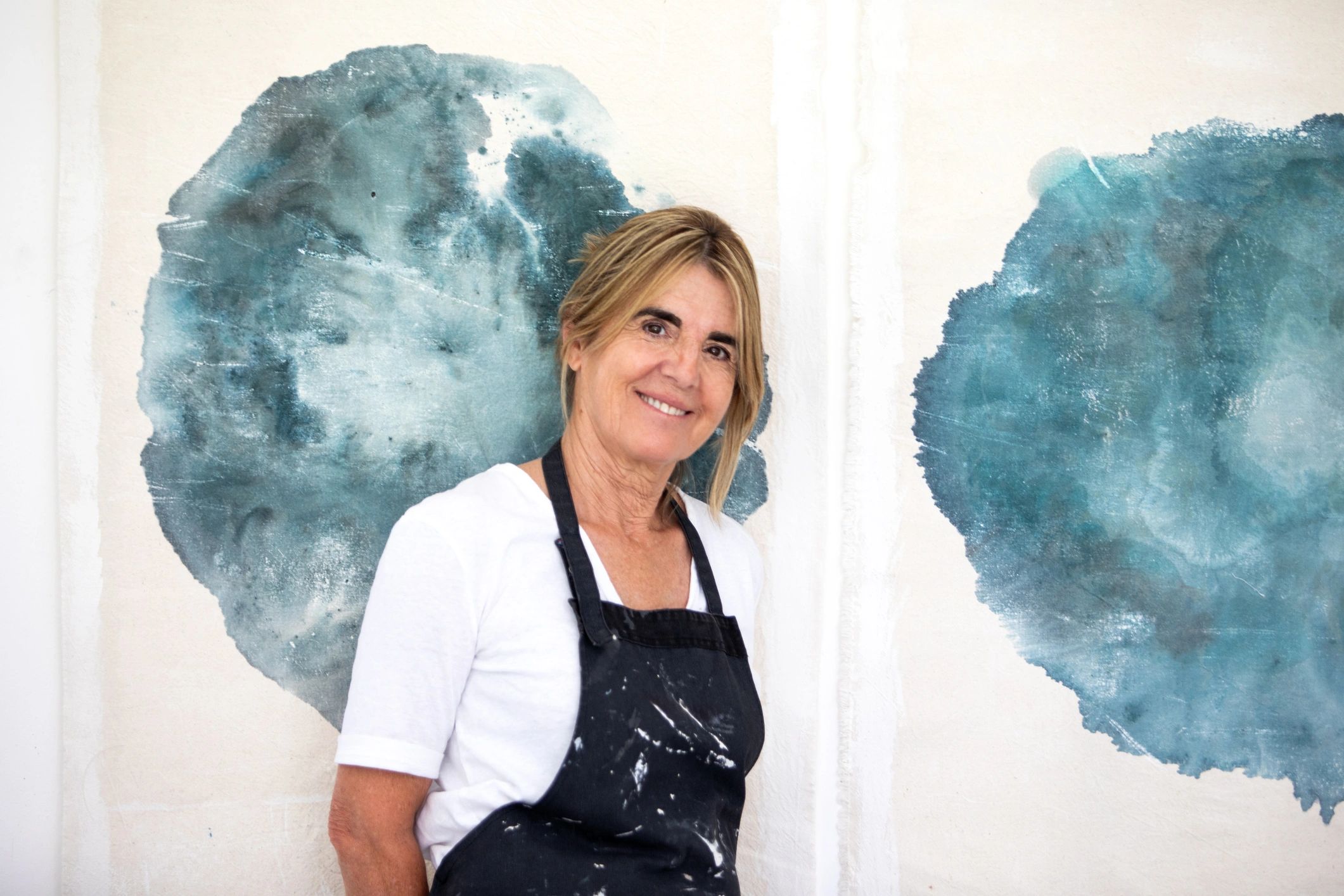 Female artist standing in front of her artwork
